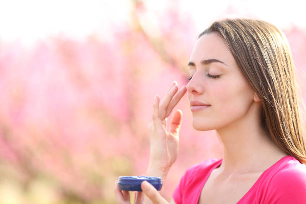 istock Woman applying moisturizer cream on face in summer 1389525558
