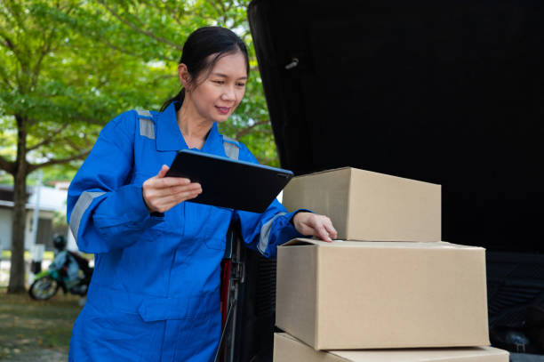istock Cheerful female courier checking parcel boxes before making home delivery 1389527001