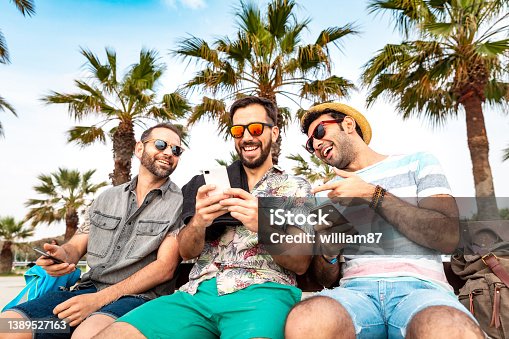 istock Multiracial group of friends using smartphone at seaside in Barcelona 1389527163