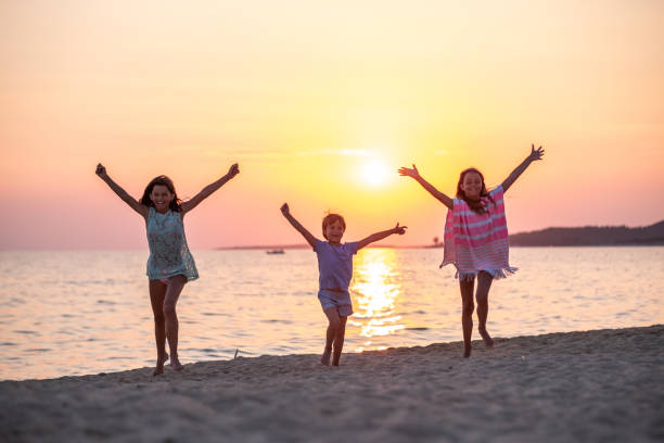 istock Two girls and a boy on the beach. 1389527234