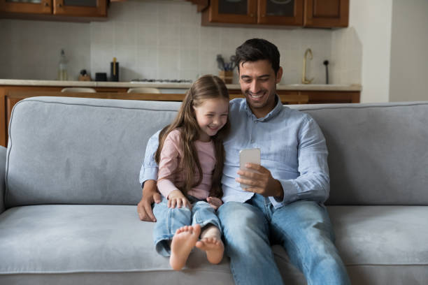 istock Happy dad and cute daughter kid using online learning app 1389527242