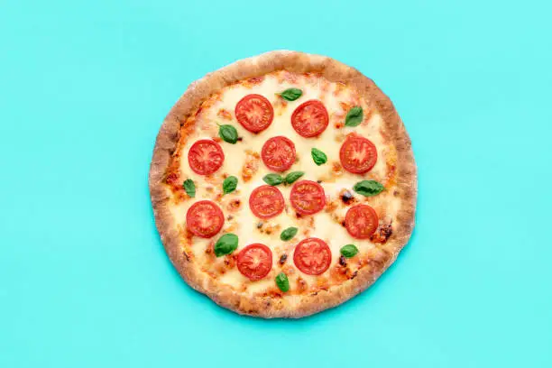 Photo of Vegetarian pizza above view, minimalist on a blue background
