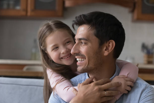 istock Happy daddy and little daughter kid hugging on sofa 1389527254