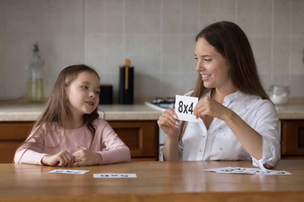 kindergärtnerin und kleines mädchen, das mathe lernt - family house flash stock-fotos und bilder