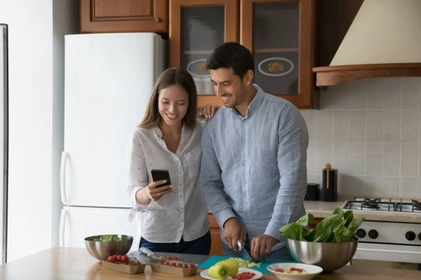 istock Happy young married couple cooking in home kitchen 1389528384