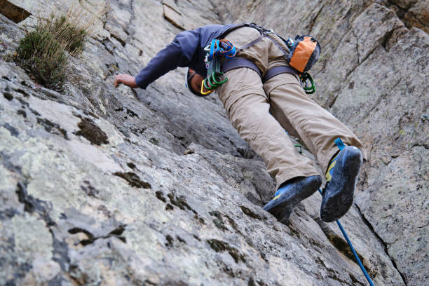 istock View from below of a man climbing a wall 1389533886