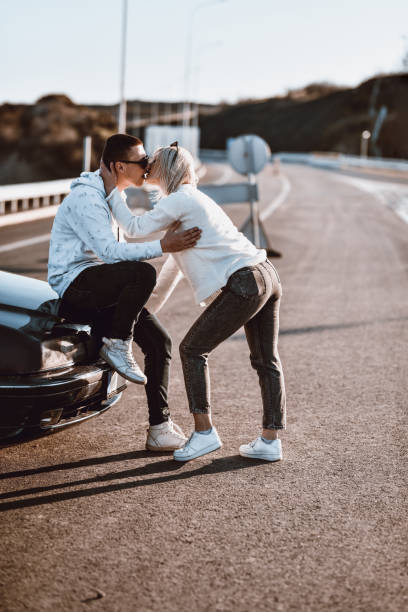 casal parando para quebrar na estrada e se beijando - acidente evento relacionado com o transporte - fotografias e filmes do acervo