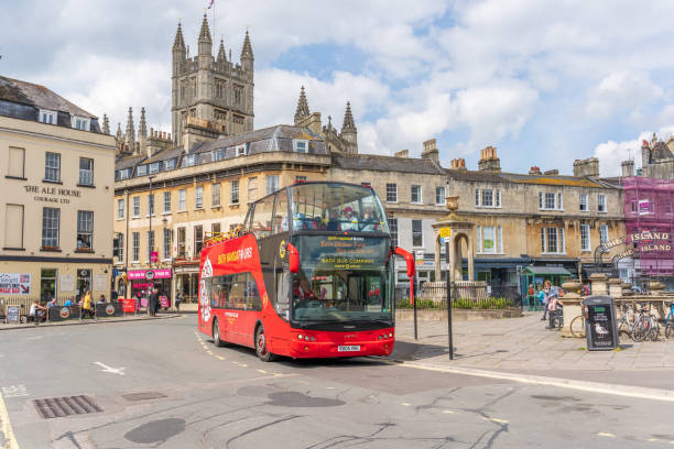 Bath, UK - July 13, 2017: Public transport buses open-top double-decker in Bath. People are pictured on the bus and on the street