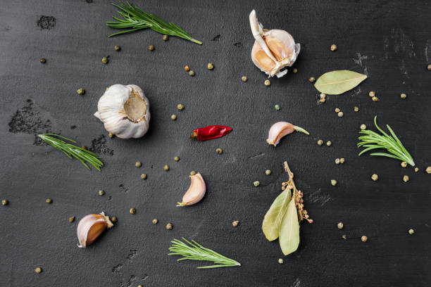 istock Garlic cloves and spices on black background 1389539592