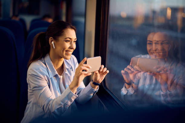 istock Happy passenger taking picture with her cell phone while traveling by train. 1389549228