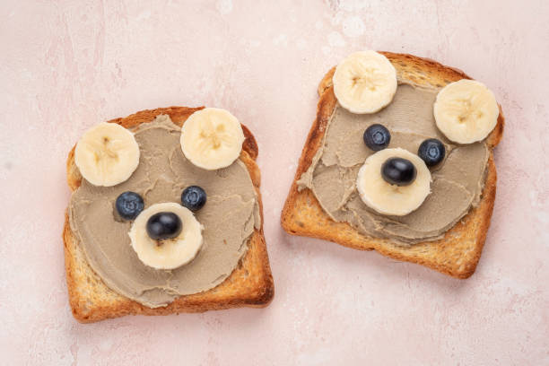 istock Funny children bear toasts with nuts butters for breakfast 1389549400