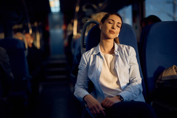 Young passenger enjoying in train ride with her eyes closed at sunset.