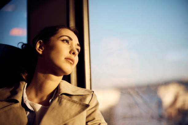 istock Thoughtful woman looking through the widow while commuting by train. 1389549447