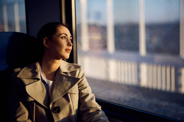 istock Pensive woman looking through the window while commuting by train at sunset. 1389549471