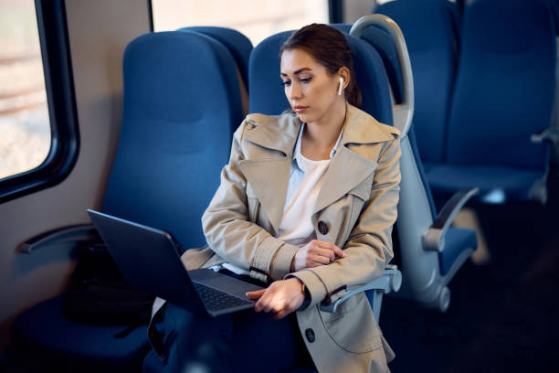 istock Young businesswoman reading an e-mail on laptop while traveling by train. 1389549556