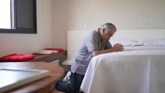 Senior man praying at home