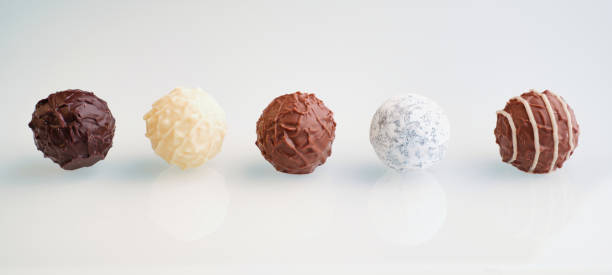 five chocolate truffles on a white background stock photo