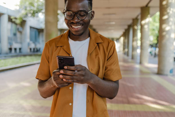 istock Young African-American man uses a mobile phone on the go 1389556352