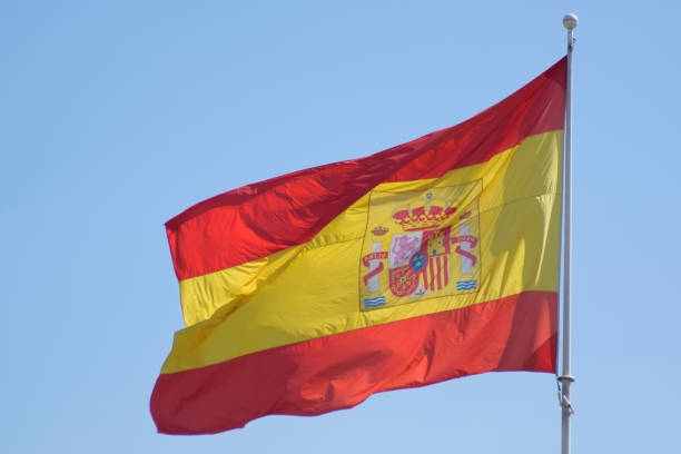 istock Spain flag waving in the blue sky 1389556503