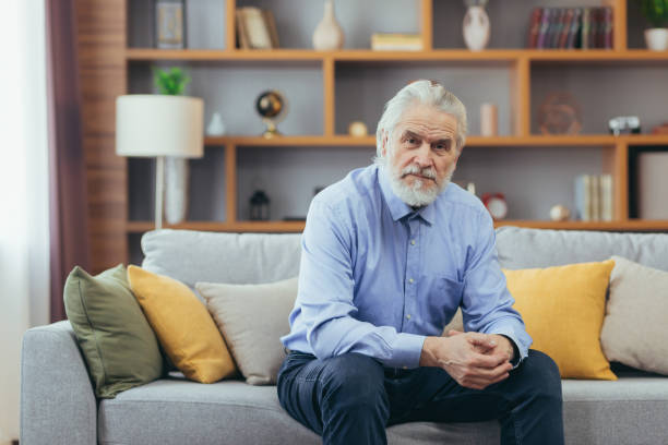 istock Serious for pensive grandfather man sitting on sofa at home 1389556576