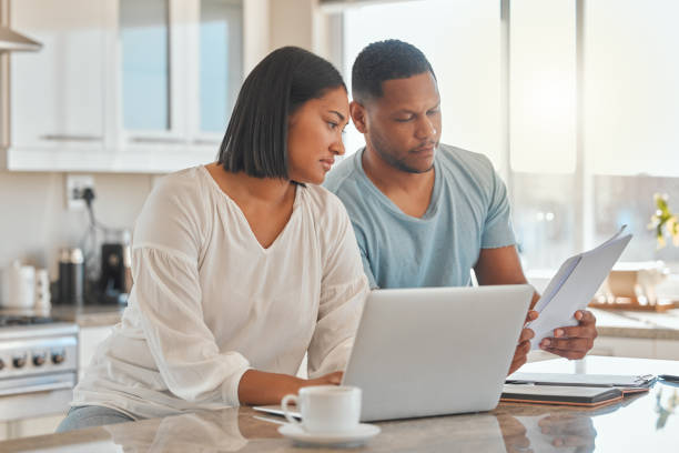 istock Shot of a couple sitting with a laptop while going over paperwork 1389558090