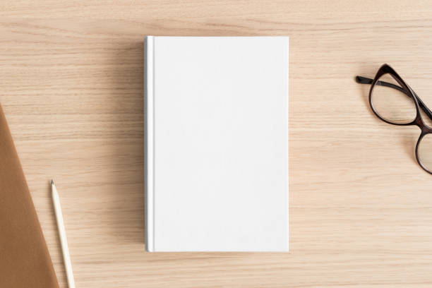 istock White book mockup with workspace accessories on the wooden table. 1389559367