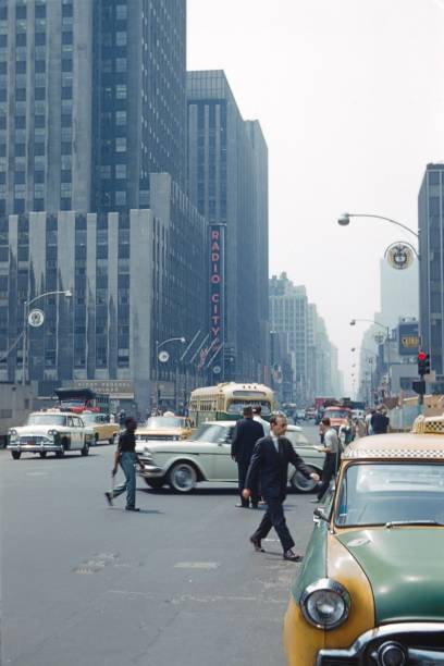 New York City, NY, USA, 1965. Street scene with pedestrians, traffic and buildings, on 6th Ave in Midtown Manhattan.