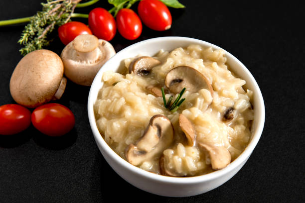 istock Bowl with mushroom risotto on black background. 1389564209