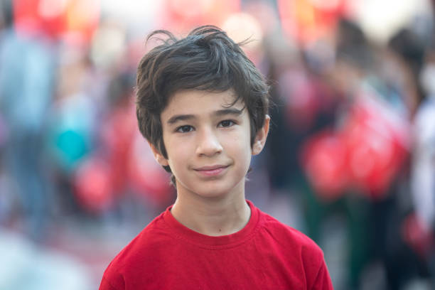 Portrait of elementary schoolboy wearing t-shirt with Turkish flag celebrating April 23 Turkish National Sovereignty and Children's Day that is 23 Nisan Ulusal Egemenlik ve Cocuk Bayrami.