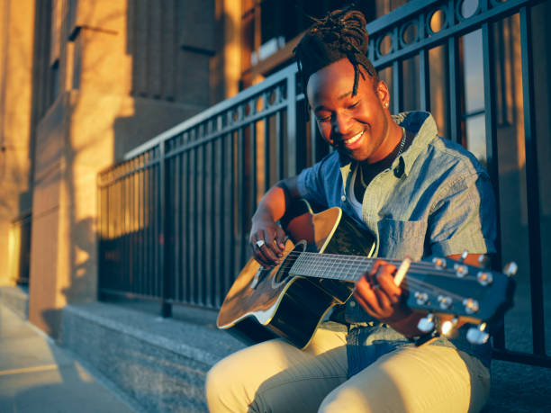 istock Young Man Playing Guitar in the City 1389570902