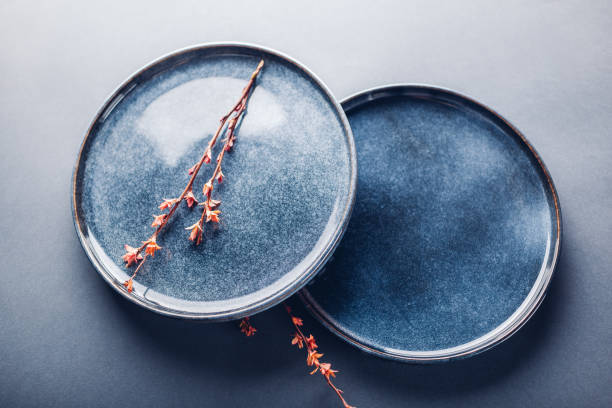 istock Handmade ceramic plates decorated with spring branches. Close up of blue vintage dishes on grey background. Space 1389572808