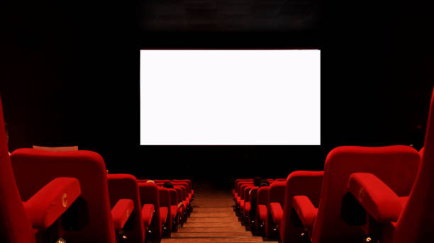 istock People in the cinema auditorium with empty white screen. 1389573550