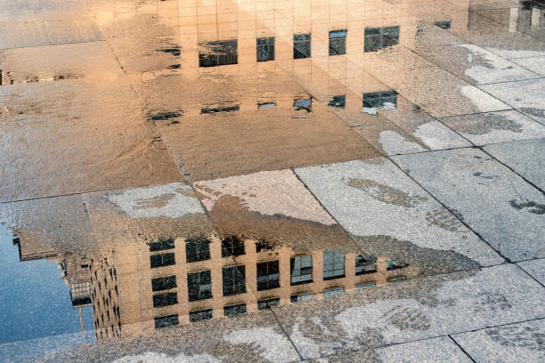 istock Reflection of modern buildings on the ground with water 1389576262