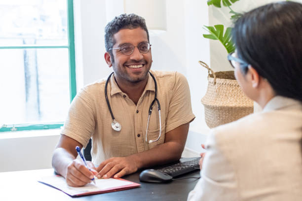 Cheerful male doctor meeting with a patient stock photo