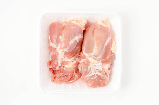 Raw Chicken thighs meat on foam tray on white background