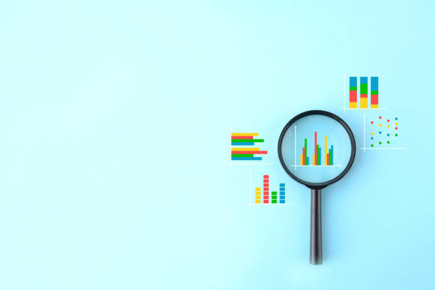 istock Magnifying glass and various business graphs on light blue background 1389582863
