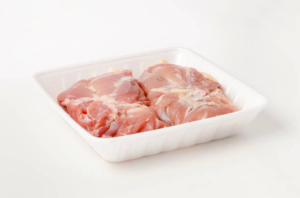 istock Raw Chicken thighs meat on foam tray on white background 1389582933
