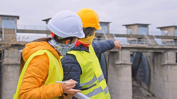 istock Maintenance engineers working in hydroelectric dam during COVID-19  with protective face masks. Ecology orientated. Renewable energy systems. 1389586183