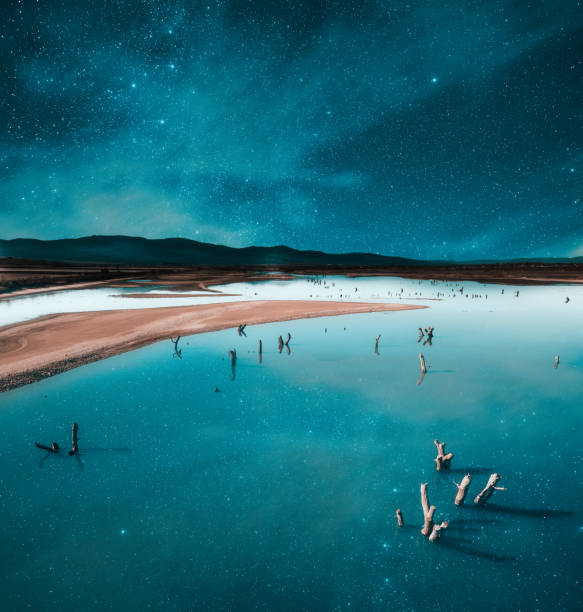 Water conservation issues. Drought in a mountain lake under starry sky.