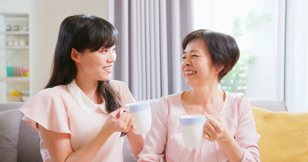 istock Mom and daughters drink together 1389590619