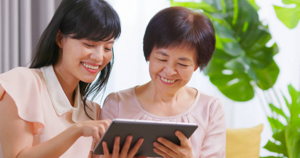 istock Daughter show tablet to mom 1389590641