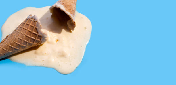 istock Melting ice cream balls with waffle cone on blue background. 1389594987
