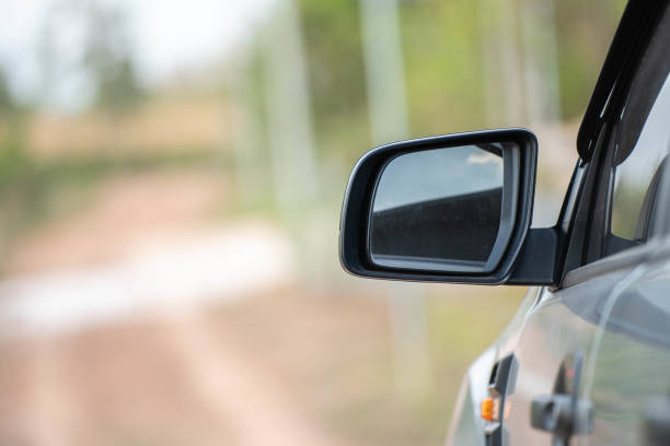 istock Car driving on the road. Blur Reflection in a car mirror.Rear view mirror reflection.Close up of car mirror with reflection of behind the car. 1389595267