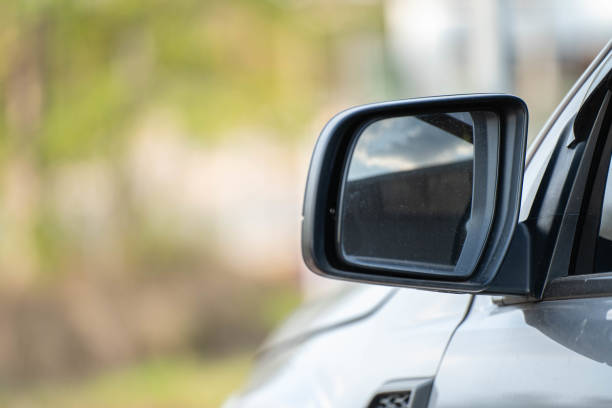 istock Car driving on the road. Blur Reflection in a car mirror.Rear view mirror reflection.Close up of car mirror with reflection of behind the car. 1389595285