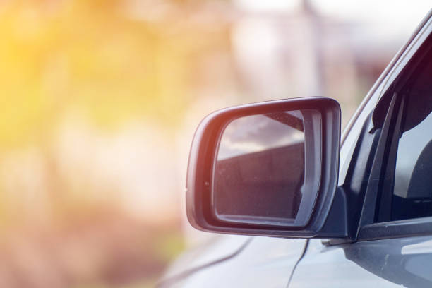 istock Car driving on the road. Blur Reflection in a car mirror.Rear view mirror reflection.Close up of car mirror with reflection of behind the car. 1389595286