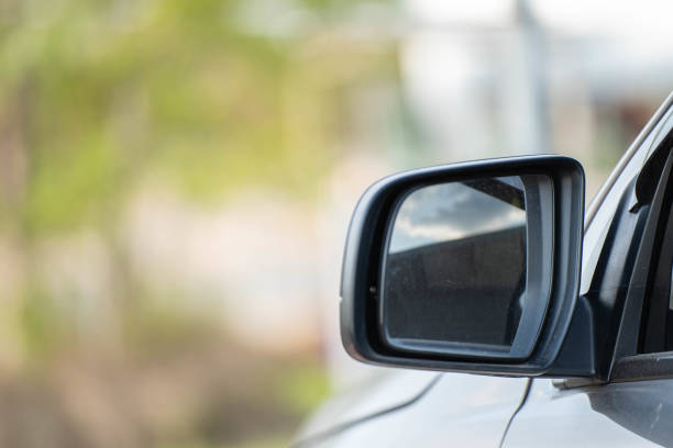 istock Car driving on the road. Blur Reflection in a car mirror.Rear view mirror reflection.Close up of car mirror with reflection of behind the car. 1389595297