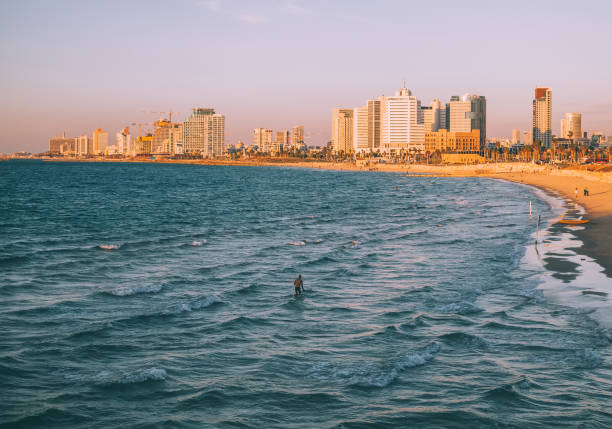 Tel Aviv, Israel, April 29 2022: Locals and tourists walking on street and seaside enjoying the sunshine and laid-back lifestyle in Tel Aviv, which is the most east part of Mediterrean Sea.