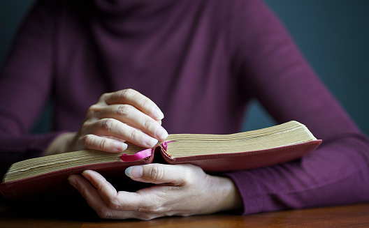 Close up view of woman holding an open Bible.