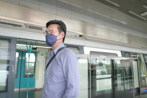 istock Man commuter with face mask on standing on subway platform. 1389601120