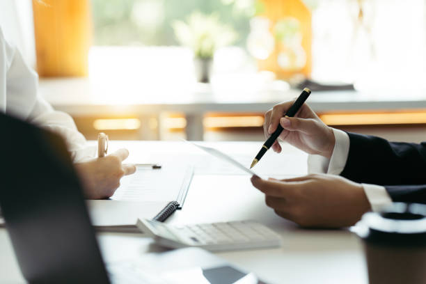 istock Financial adviser working with client, calculating and analyzing data at the table in office. 1389602462